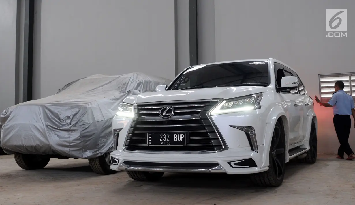 Petugas Rumah Penyimpanan Benda Sitaan Negara (Rupbasan) Klas 1 Jakarta Barat dan Tangerang  merapikan mobil milik Bupati Hulu Sungai Tengah Abdul Latif di Tangerang, Selasa (20/3). Rupbasan ini mampu menampung 50 kendaraan. (Merdeka.com/Arie Basuki)