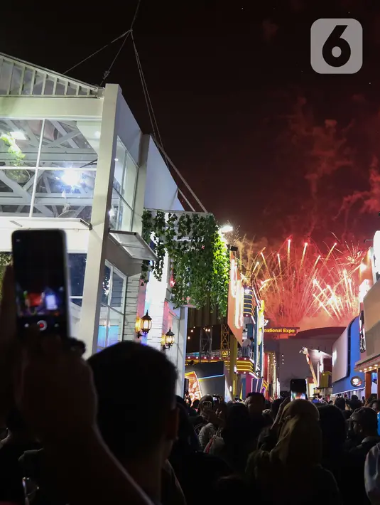 Pengunjung menyaksikan pesta kembang api di langit saat Jakarta Fair ke-53 atau Pekan Raya Jakarta (PRJ) di JiExpo Kemayoran, Jakarta Pusat, Selasa (21/6/2022) malam. Pesta kembang api menggelegar di kawasan PRJ bertepatan dengan HUT Jakarta yang jatuh pada besok, 22 Juni 2022. (Liputan6.com/Herman Zakharia)