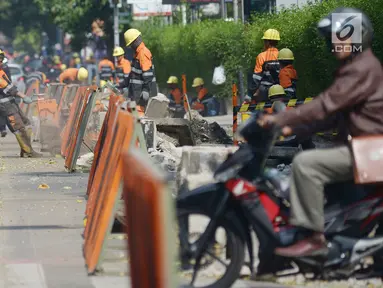 Pekerja membongkar trotoar lama di Jalan Cikini Raya, Taman Ismail Marzuki (TIM), Jakarta, Selasa (18/6/2019). Revitalisasi trotoar TIM hingga Jalan Diponegoro sepanjang 10 kilometer mulai dikerjakan. (merdeka.com/Imam Buhori)
