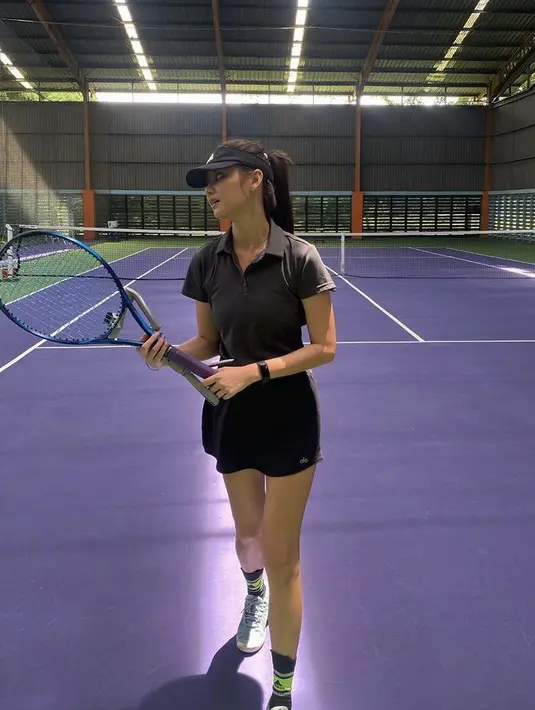 Gege diketahui gemar berolahraga tenis, ia mengenakan atasan polo shirt hitam yang serasi dengan mini skirtnya.  Credit: @gegeelisa94