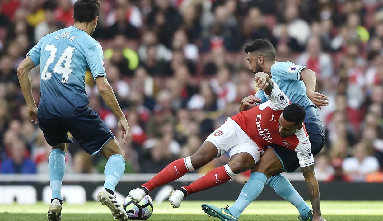 Penyerang Arsenal, Theo Walcott, terjatuh saat berebut bola dengan pemain Everton pada laga Premier League di Stadion Emirates, London, Sabtu (15/10/2016). Arsenal menang 3-2 atas Swansea. (Reuters/Hannah McKay)