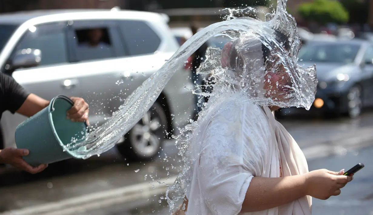 Orang-orang saling memercikkan air di pusat kota Yerevan selama liburan tahunan Vardavar pada 16 Juli 2023. (Photo by Karen MINASYAN / AFP)