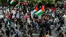 Para pengunjuk rasa memegang plakat dan mengibarkan bendera Palestina saat mereka mengambil bagian dalam “Pawai Nasional untuk Gaza”, di pusat kota London, pada 8 Juni 2024. (JUSTIN TALLIS/AFP)