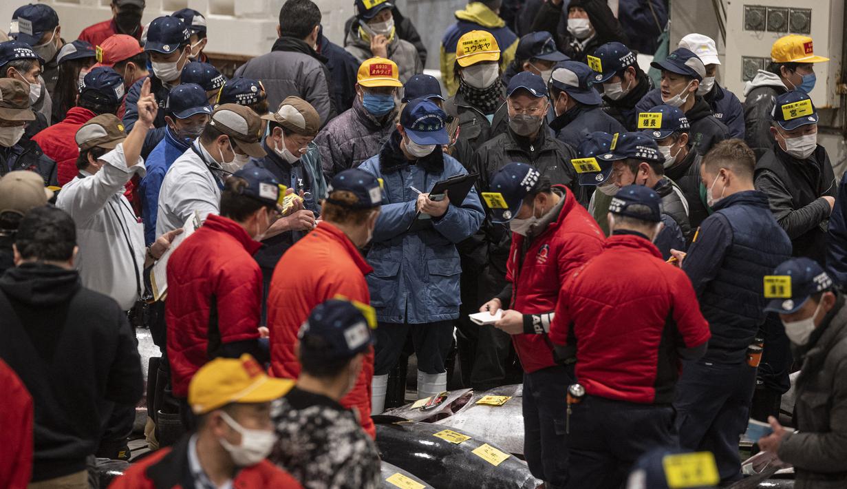 Penjual dan pembeli grosir menghadiri lelang tuna pertama Tahun Baru di pasar ikan Toyosu di Tokyo (5/1/2023). Pada tahun ini, lelang tuna tertinggi terjual lebih dari USD 270.000. Hampir dua kali lipat dari harga tahun lalu. (AFP/Richard A. Brooks)