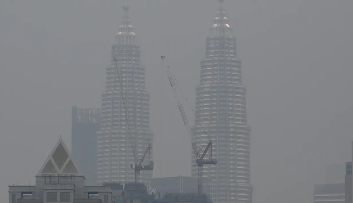Menara Kembar Petronas diselimuti kabut asap di Kuala Lumpur, Malaysia (10/9/2019). Departemen Pendidikan Kota Sarawak, Malaysia meminta sekolah-sekolah ditutup sementara menyusul memburuknya udara akibat kabut asap kebakaran hutan di wilayah itu. (AFP Photo/Mohd Rasfan)