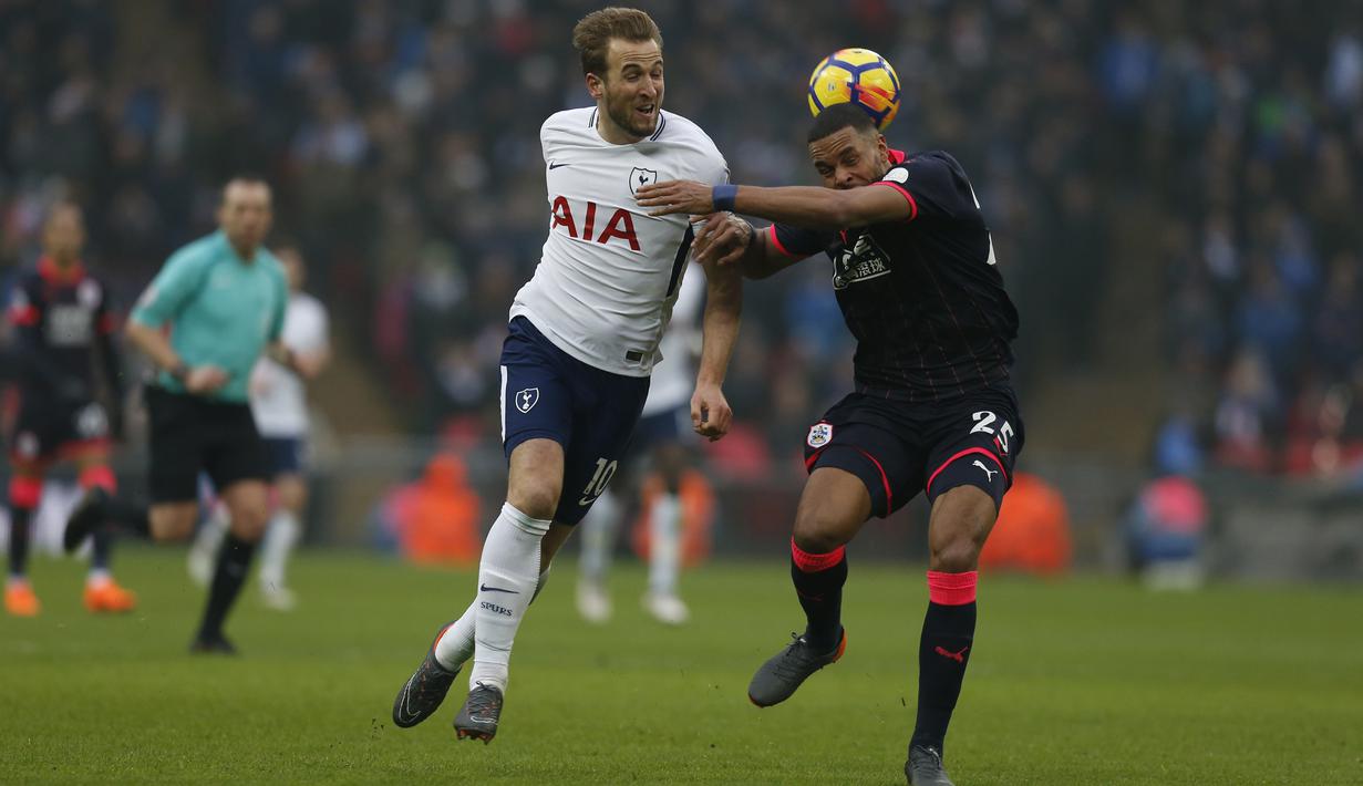 Pemain Tottenham, Harry Kane (kiri) berebut bola dengan pemain Huddersfield Town, Mathias Jorgensen pada laga Premier League di Wembley Stadium, London, (3/3/2018). Tottenham menang 2-0. (AFP/Ian Kington)