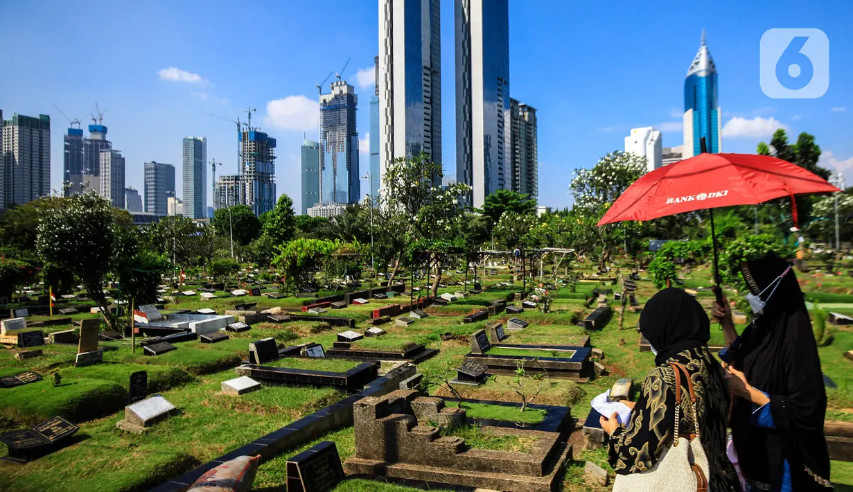 Warga melintas di antara makam di TPU Karet Bivak, Jakarta, Selasa (11/5/2021). Pemprov DKI akan memberlakukan larangan ziarah kubur Idulfitri di seluruh TPU mulai 12 hingga 16 Mei untuk mencegah terjadinya penyebaran Covid-19 saat berkumpul untuk berziarah. (Liputan6.com/JohanTallo)