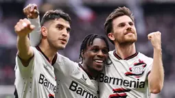 Para pemain Bayer Leverkusen merayakan gol yang dicetak oleh Jeremie Frimpong ke gawang Eintracht Frankfurt pada laga Liga Jerman di Stadion Deutsche Bank Park, Senin (6/5/2024). (AFP/Kirill Kudryavtsev)