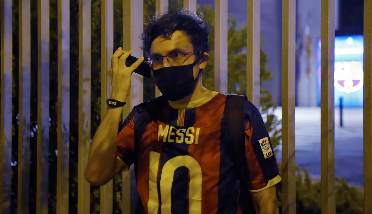 Suporter memakai jersey Lionel Messi mengikuti protes di depan kantor Barcelona, Selasa (25/8/2020). Aksi tersebut merupakan respon fans atas kabar Lionel Messi yang akan meninggalkan Camp Nou pada musim panas ini. (AFP/Pau Barrena)