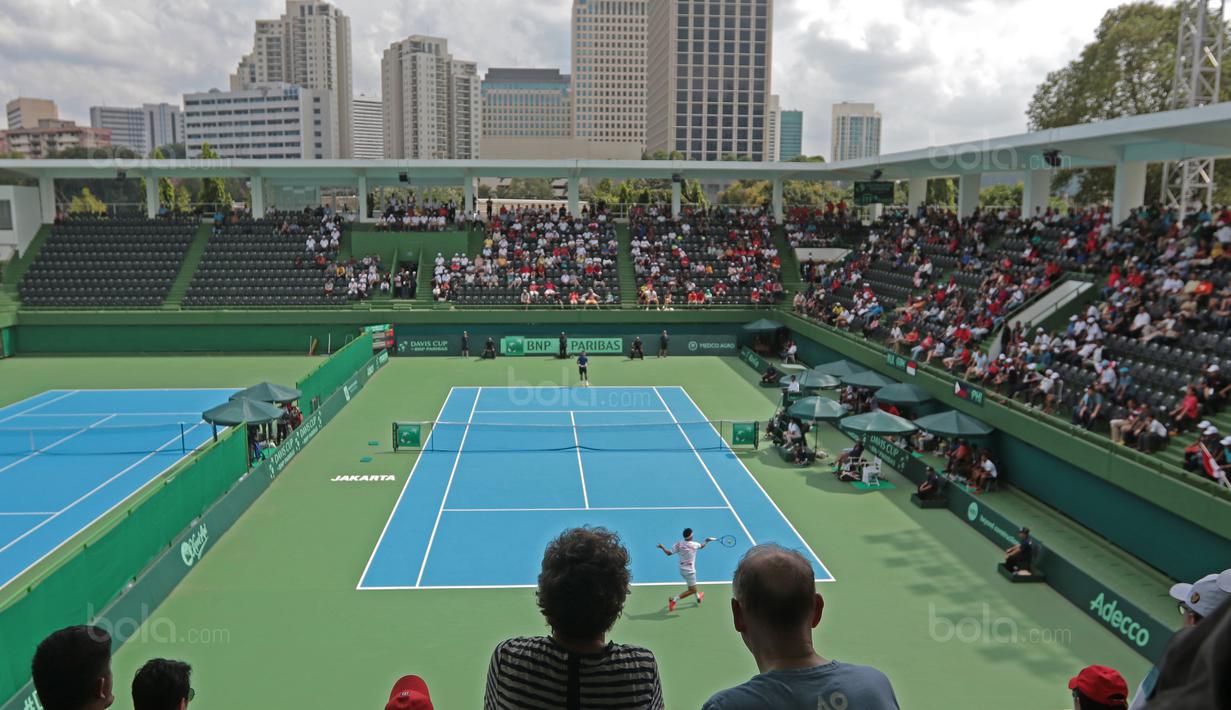 Aksi David Agung Susanto mengembalikan bola saat melawan petenis Filipina, Jeson Patrombon pada Piala Davis 2018 grup dua Asia/Oceania di Senayan, Jakarta, Sabtu (3/2/2018). David menang 6-2, 7-5. (Bola.com/Nick Hanoatubun)