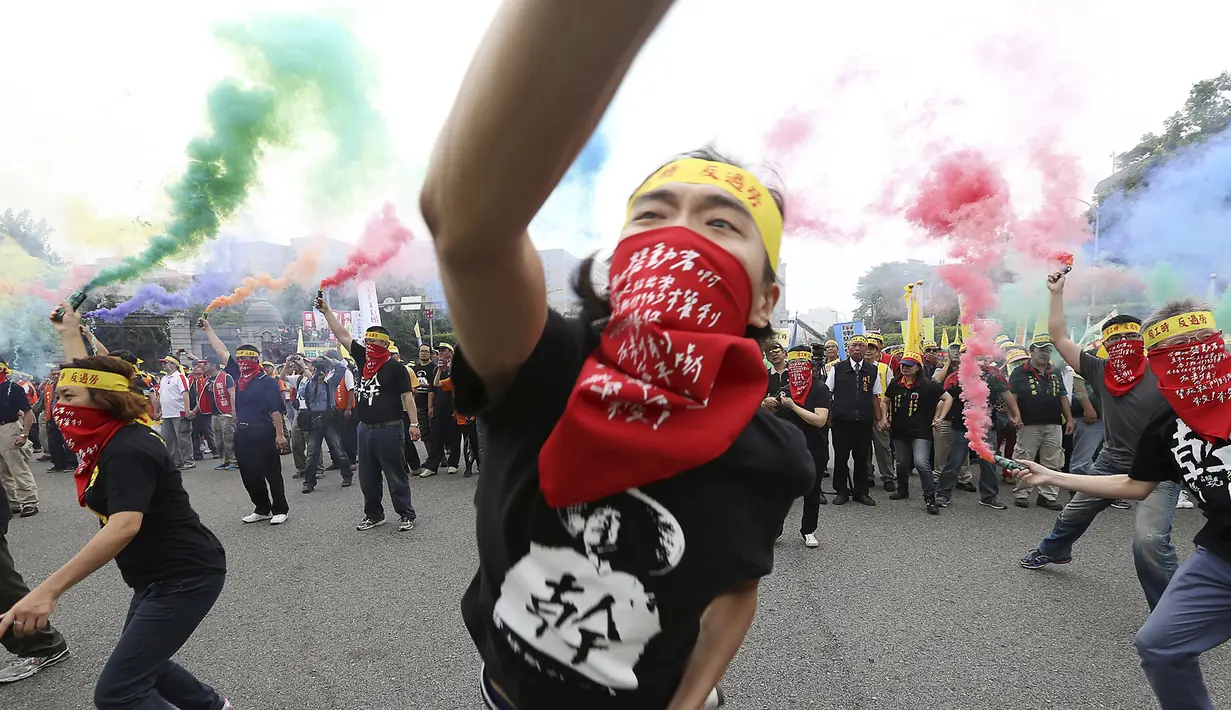 Seorang pengunjuk rasa melemparkan granat asap saat menggelar aksi demonstrasi Hari Buruh Internasional (May Day) di depan Kantor Kepresidenan di Taipei, Taiwan, Jumat (1/5/2015). (REUTERS/Patrick Lin)