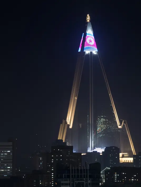 Pertunjukan cahaya menampilkan bendera Korea Utara di atas hotel Ryugyong di kota Pyongyang, Korea Utara (9/4). (AFP Photo/Ed Jones)