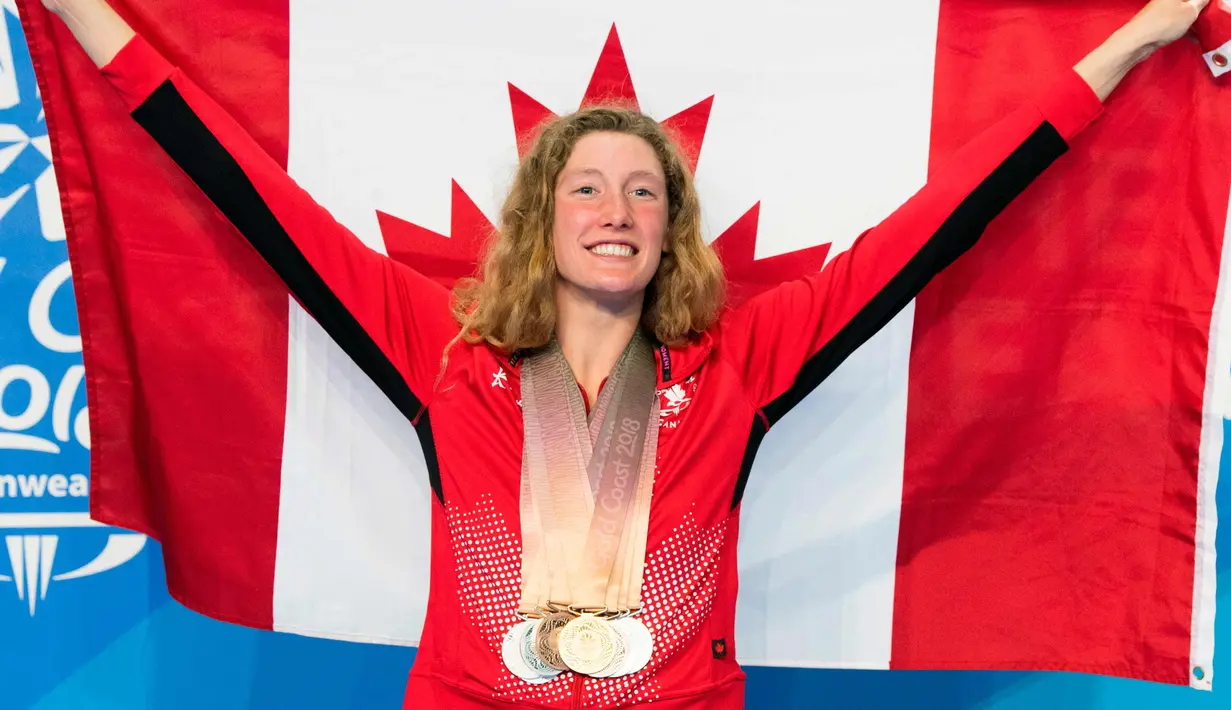 Ruck Taylor membentangkan bendera Kanada dengan delapan medali yang dikalunginya di Commonwealth Games 2018 di Gold Coast, Australia (10/4). Ruck mencatatkan rekor dari atlet lainnya dengan memenangkan medali terbanyak. (AP Photo/Ryan Remiorz)