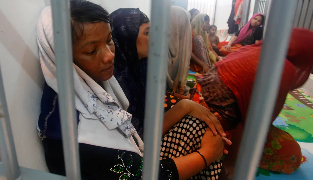 Muslim Rohingya duduk di balik jerusi besi di sebuah kantor polisi di Provinsi Satun, Thailand Selatan pada 11 Juni 2019. Sebanyak 65 Muslim Rohingya ditemukan di sebuah kapal yang nyaris karam di bagian selatan negara itu. (Department of National Parks Wildlife and Plant Conservation via AP)