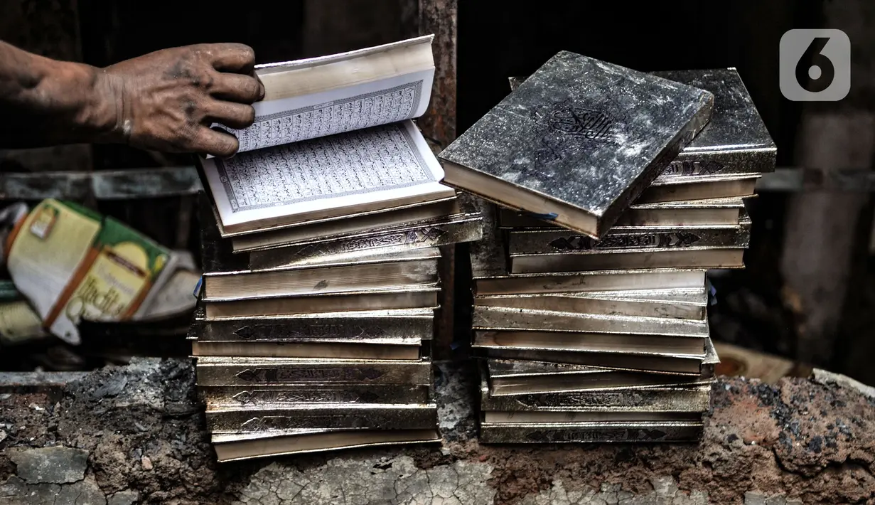 Pekerja menunjukkan Alquran yang selamat dari kebakaran di Toko Buku Setia Kawan, Senen, Jakarta, Rabu (14/10/2020). Pemilik toko empat lantai tersebut mengaku sekitar puluhan ribu buah buku hangus terbakar dengan kerugian mencapai Rp3 miliar. (merdeka.com/Iqbal Nugroho)