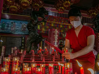 Warga keturunan Tionghoa menyalakan lilin saat sembahyang di Vihara Amurva Bhumi, Jakarta, Kamis (11/2/2021). Sembahyang jelang Imlek ini sebagai ungkapan syukur atas rejeki dan keselamatan dari Tuhan serta untuk pengharapan kehidupan lebih baik di tahun Kerbau Logam. (Liputan6.com/Faizal Fanani)