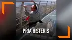 Seorang pria tampak ketakutan saat berada di atas jembatan kaca. Ia tak mampu berdiri dan berteriak histeris meminta pertolongan. Aksinya itu mengundang tawa orang-orang di sekitarnya.