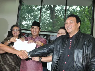 Wakil Ketua nonaktif KPK Bambang Widjojanto atau BW (kiri) menerima hasil penyidikan dari Ketua Bidang Pembelaan Profesi Peradi Hendrik Jehaman (kanan) di YLBHI, Jakarta, Jumat (15/5). (Liputan6.cpm/Herman Zakharia)