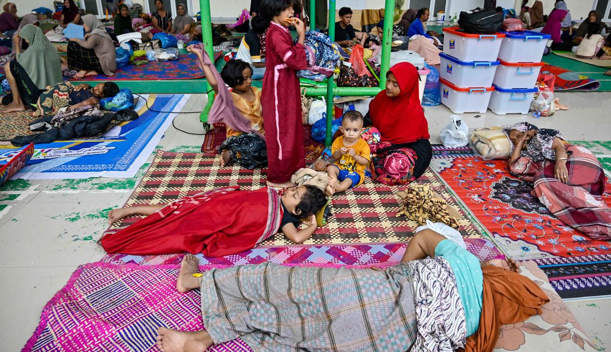 Korban jiwa akibat bencana di Pidie Jaya sementara ini tercatat ada 10 orang, empat masih hilang, dan 101 lainnya luka-luka. Tampak dalam foto, warga desa terdampak banjir beristirahat di tempat pengungsian setelah banjir bandang melanda Meureudu, Kabupaten Pidie Jaya, Provinsi Aceh, pada 29 November 2025. (CHAIDEER MAHYUDDIN/AFP)