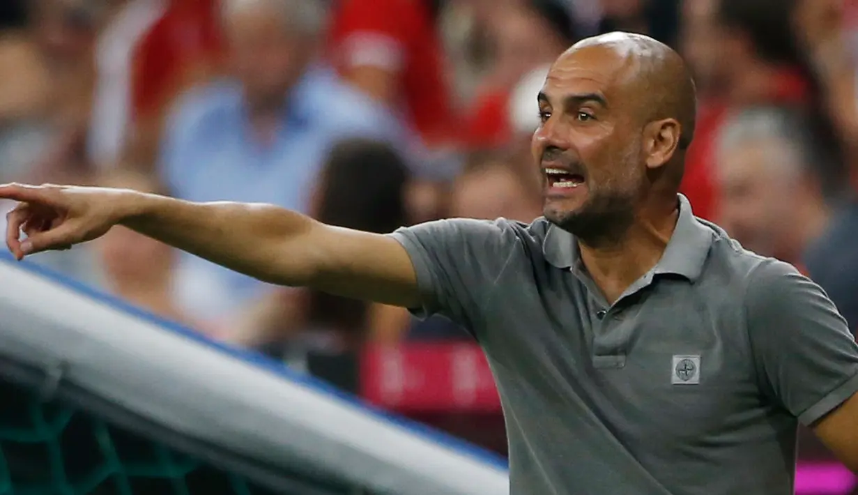 Pep Guardiola mengintruksikan pemainnya saat bertanding melawan Bayern Muenchen di laga pramusim di Allianz Arena, Muenchen (21/7). Muenchen sendiri merupakan mantan klub yang pernah ditangani Guardiola selama tiga musim. (Reuters/Michaela Rehle)