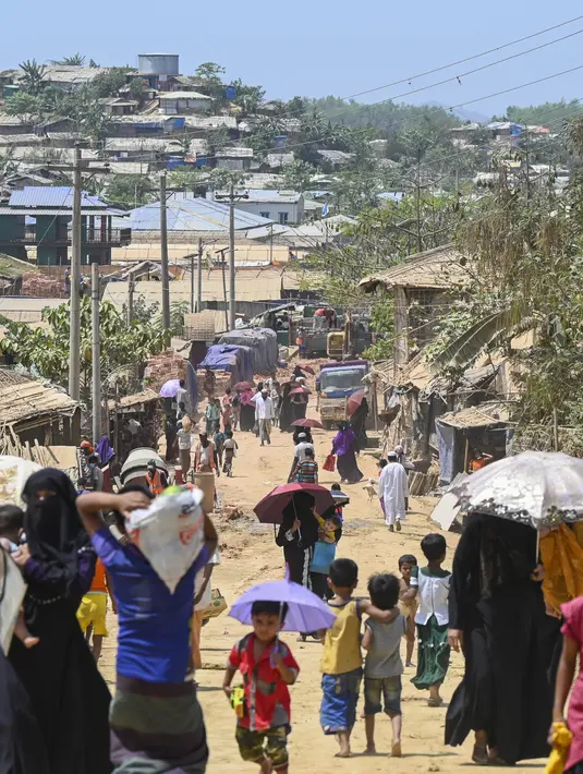 Para pengungsi Rohingya berjalan di kamp pengungsi Jamtoli di Ukhia (22/3/2022). Ratusan ribu orang Rohingya melarikan diri dari Myanmar yang mayoritas beragama Buddha setelah tindakan keras tahun 2017, yang menjadi subjek kasus genosida di pengadilan tertinggi PBB di Den Haag. (AFP/Munir Uz Zaman)
