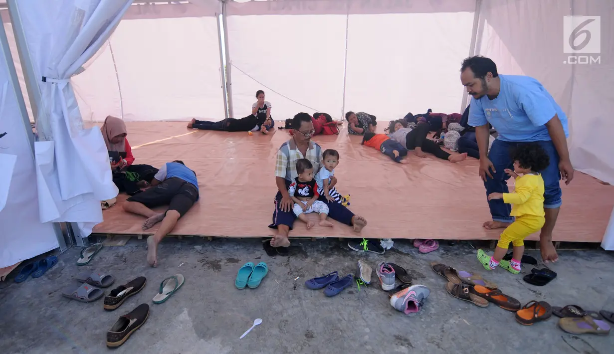 Sejumlah pemudik beristirahat di tenda "rest area alternatif" Km 153 Cipali, Jawa Barat, Rabu (21/6). Untuk melepas lelah, sebagian pemudik berhenti dan beraktivitas di sejumlah area peristirahatan sementara yang tersedia. (Liputan6.com/Gempur M Surya)