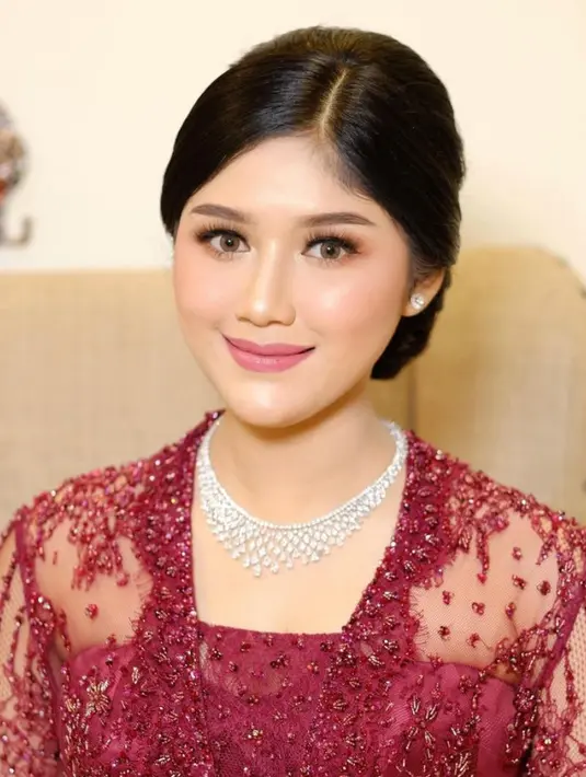 Melengkapi tampilannya dengan kalung emas putih serta anting-anting minimalis. Rambutnya ditata sanggul updo dengan poni sampingnya. [@erinagudono]