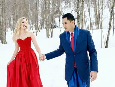 Kemesraan Panji dan Varsha saat liburan ke Jepang. Terlihat gagah dengan balutan jas biru dan istrinya elegan dengan balutan gaun merah yang menyala diantara salju putih (Liputan6.com/IG/@varshaadhikumoro)
