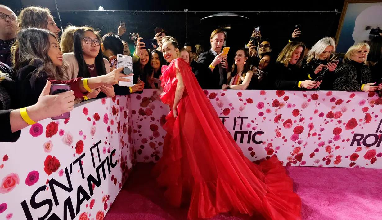 Penyanyi Miley Cyrus foto bersama fans saat tiba menghadiri pemutaran perdana film "Isn't It Romantic" di Los Angeles (11/2). Miley Cyrus menghadiri pemutaran film tersebut menggantikan suaminya Liam Hemsworth yang sakit. (AFP Photo/Alberto E. Rodriguez)