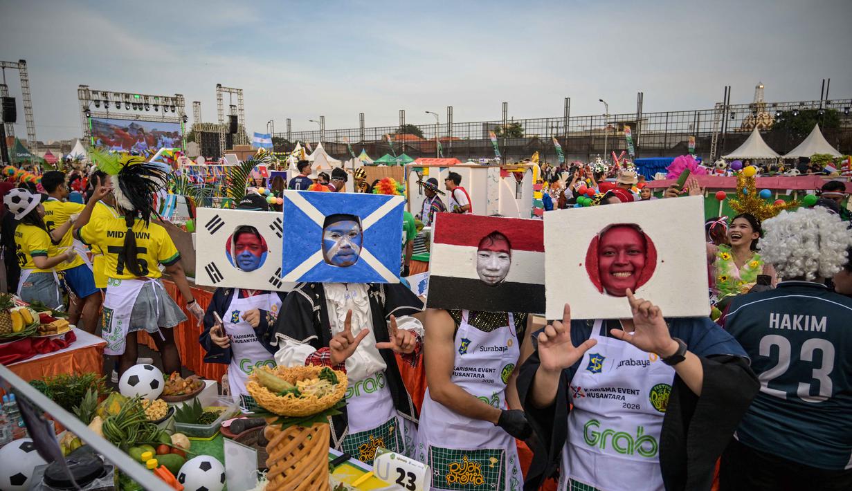 Sebagai informasi, sejak 2023, Festival Rujak Uleg telah menjadi bagian dari Karisma Event Nusantara (KEN) Kementerian Pariwisata Republik Indonesia. Tampak dalam foto, para peserta yang mengenakan bendera nasional tim sepak bola menari sebelum menyiapkan rujak uleg, salad gurih tradisional Indonesia yang berisi moncong sapi dan sayuran, dalam Festival Rujak Uleg 2026 di Surabaya, Jawa Timur, Sabtu 9 Mei 2026. (JUNI KRISWANTO/AFP)