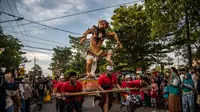 Umat Hindu membawa Ogoh-Ogoh selama pawai di kawasan Pura Segara sehari sebelum Hari Raya Nyepi di Surabaya pada 21 Maret 2023. (AFP/Juni Kriswanto)