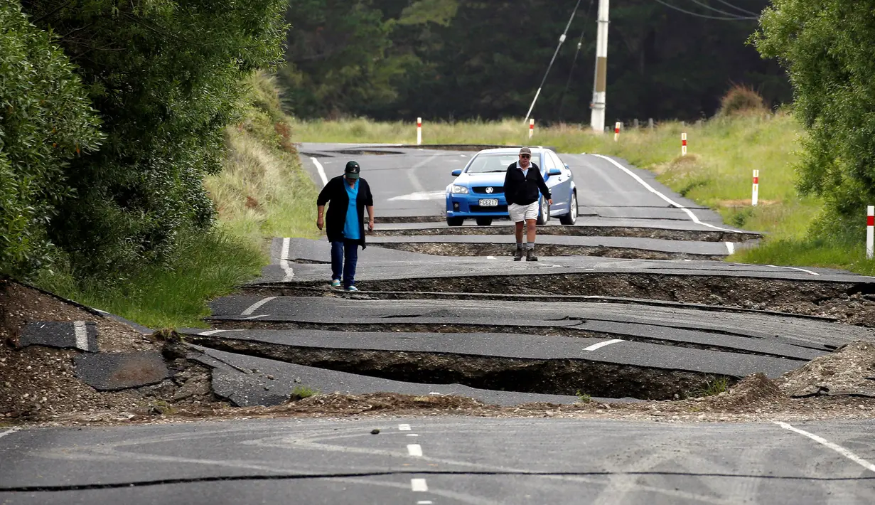 Warga melihat jalan retak di jalan raya State Highway One, sebelah selatan dari Blenheim di Pulau Selatan, Selandia Baru, Senin (14/11). Gempa 7,8 SR yang mengguncang Selandia Baru mengakibatkan jalan tersebut retak. (REUTERS/Anthony Phelps)