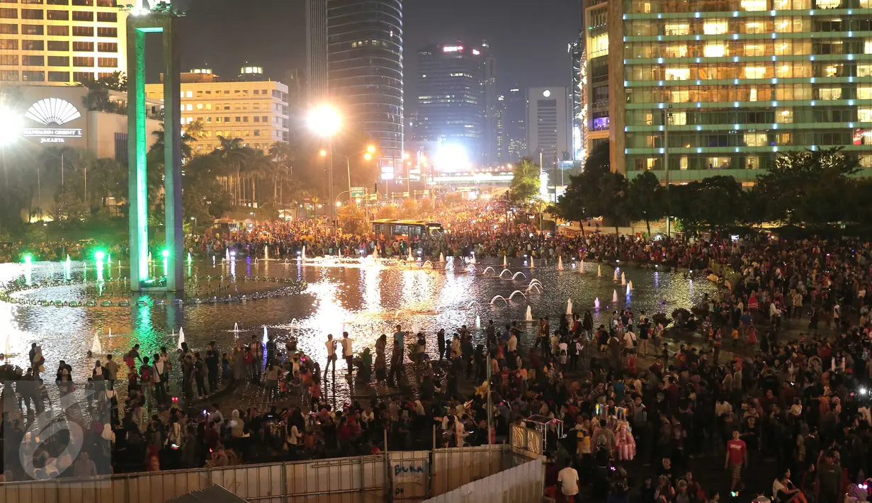 Warga memadati kawasan Bundaran HI, Jakarta, Kamis (31/12). Ribuan warga berkumpul untuk menikmati Car free night malam perayan pergantian tahun bersama keluarga. (Liputan6.com/Angga Yuniar)