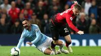 Gelandang Manchester City, Ilkay Gundogan berebut bola dengan pemain Manchester United, Luke Shaw dalam laga lanjutan Liga Inggris di Stadion Old Trafford, Rabu (24/4). Laga Man United vs Man City berakhir dengan kemenangan 2-0 untuk tim asuhan Josep Guardiola. (AP/Jon Super)