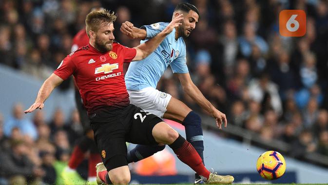 Bek Manchester United, Luke Shaw, berebut bola dengan gelandang Manchester City, Riyad Mahrez, pada laga Premier League di Stadion Etihad, Manchester, Minggu (11/11). City menang 3-1 atas MU. (AFP/Oli Scarff)