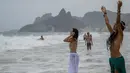 Tanpa riskan, kedua wanita ini asyik melakukan ritual Lemanja meski tak menutup dadanya, Pantai Arpoador, Rio de Janeiro, Brasil, Senin (2/2/2015). (AFP Photo/Yasuyoshi Chiba)