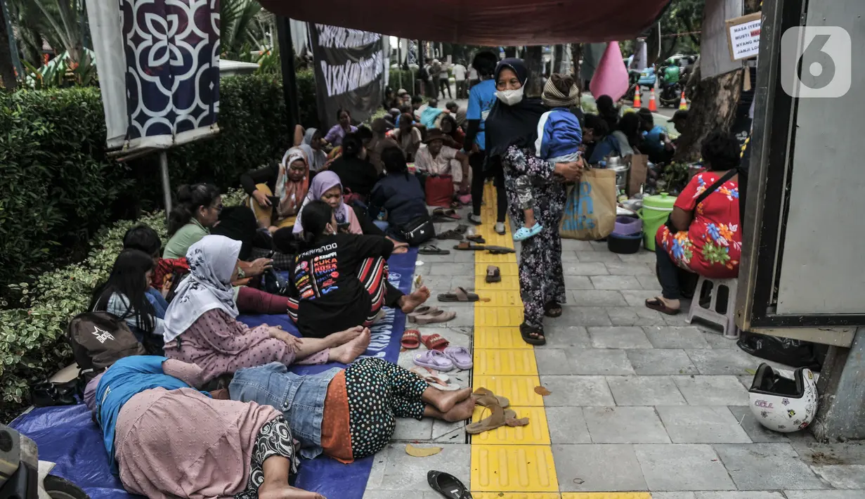 Warga tertidur saat menggelar aksi di depan Balai Kota, Jakarta, Senin (5/12/2022). Dengan membawa terpal dan perabotan rumah tangga, puluhan korban gusuran Kampung Bayam kembali membangun tenda darurat di depan Balai Kota untuk menuntut PT Jakarta Propertindo (JakPro) segera menyerahkan kunci hunian Kampung Susun Bayam (KSB) serta memberikan harga sewa yang murah. (merdeka.com/Iqbal S. Nugroho)