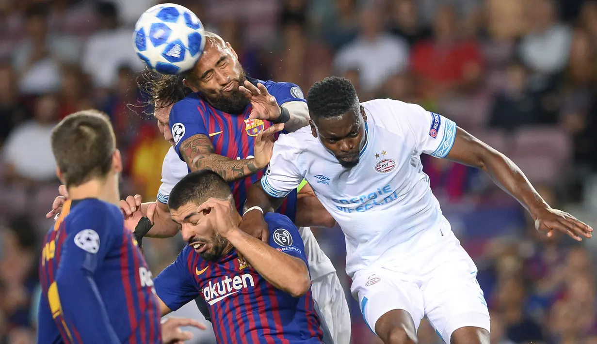 Gelandang Barcelona, Arturo Vidal, duel udara dengan bek PSV Eindhoven, Nicolas Isimat-Mirin, pada laga Liga Champions di Stadion Camp Nou, Barcelona, Selasa (18/9/2018). Barcelona menang 4-0 atas PSV. (AFP/Josep Lago)