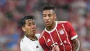 Striker Liverpool, Roberto Firmino, menahan laju gelandang Bayern Munchen, Corentin Tolisso, pada laga Audi Cup di Stadion Allianz Arena, Munchen, Selasa (1/8/2017). Munchen kalah 0-3 dari Liverpool. (AFP/Christof Stache)