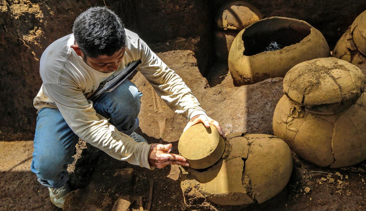 Pekerja mengamati tembikar berusia lebih dari 1.200 tahun yang ditemukan di lokasi pembangunan Stadion Bisbol Nasional yang baru di Managua, Nikaragua, Selasa (20/6). Barang-barang yang ditemukan akan dipamerkan di Museum Budaya Nasional. (INTI OCON/AFP)