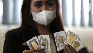 Pramuniaga menunjukkan emas batangan PT Aneka Tambang (Antam) Tbk di sebuah gerai emas, Jakarta, Senin (18/1/2021). Pada hari ini, harga emas Antam turun menjadi Rp 944 ribu per gram. (Liputan6.com/Johan Tallo)