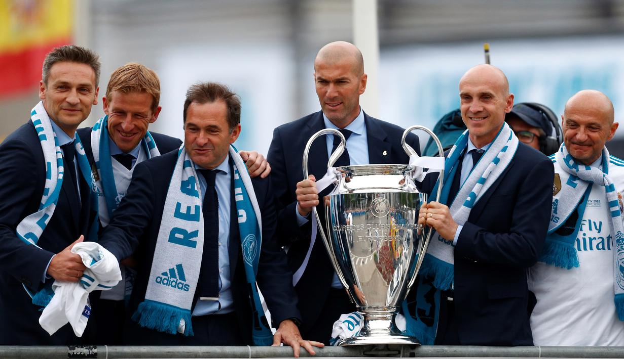 Zidane bersama asisten pelatih Real Madrid saat meraih trofi Liga Champions 2018 di Cibeles square, Madrid (27/5/2018).  Zidane mundur dari kursi pelatih Madrid setelah meraih trofi Liga Champions tiga kali. (AFP/Benjamin Cremel)