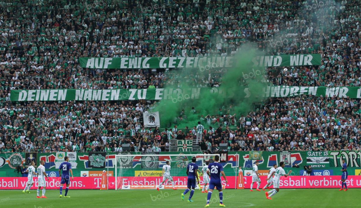 Fans Rapid Wien menyalakan bom asap di tengah berlangsungnya laga uji coba melawan Chelsea di Stadion Allianz, Sabtu (16/7/2016). (Bola.com/Reza Khomaini)