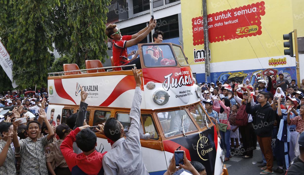 Tontowi Ahmad berselfie ria di tengah kemeriahan penyambutan kirab bersama Liliyana Natsir di kota Kudus, Kamis (1/9/2016). (Bola.com/Arief Bagus).