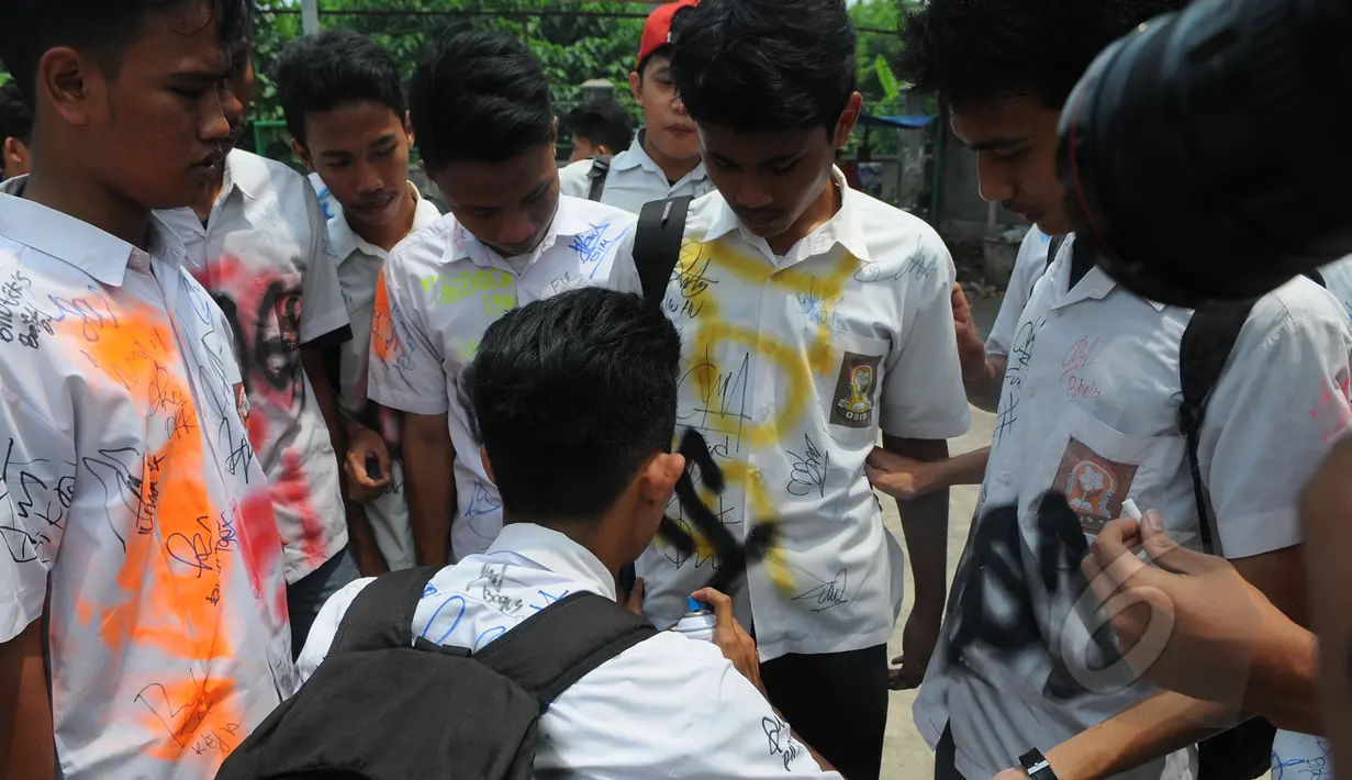 Pelajar SMK Kemala Bhayangkari 1 Jakarta, mencoret seragam rekannya usai mengikuti Ujian Nasional (UN), Kamis (16/4/2015). Aksi tersebut dilakukan sebagai bentuk kegembiraan usai mengikuti UN. (Liputan6.com/Herman Zakharia)