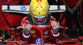 Pembalap Ferrari, Lewis Hamilton masuk ke kokpit mobilnya dalam sesi latihan bebas Formula 1 GP Australia 2025 di Sirkuit Albert Park, Melbourne, Australia pada Jumat (14/03/2025). (AFP/Saeed Khan)