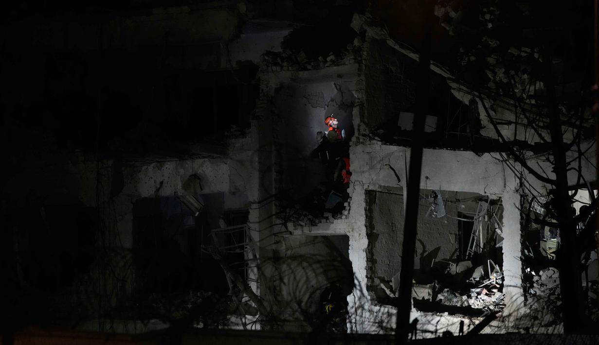 Serangan-serangan rudal dari Iran itu mengaktifkan sirene peringatan serangan udara di beberapa wilayah Israel. Tampak dalam foto, para petugas dari Komando Pertahanan Dalam Negeri Israel memeriksa reruntuhan gedung apartemen yang rusak akibat serangan rudal Iran di Tel Aviv, Israel, Sabtu 28 Februari 2026. (AP Photo/Ohad Zwigenberg)