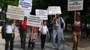 Sejumlah pria bertubuh tinggi berjalan sambil membawa poster saat melakukan pertemuan di Champs-Elysees Avenue di Paris, Prancis (14/6/2019). Kemunculan mereka di Champs-Elysees Avenue sampai mengundang perhatian warga dan penyiar televisi. (AFP Photo/Dominique Faget)