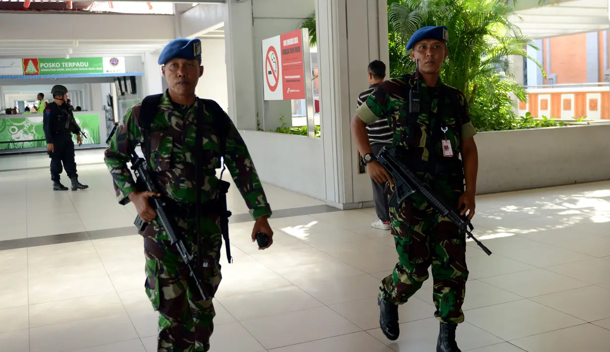 Dua anggota TNI AU melakukan patroli di Bandara Ngurah Rai, Denpasar, Bali, Jumat (15/1). Pasca terjadinya aksi teror di Sarinah, Jakarta, Bandara Ngurah Rai sebagai salah satu pintu masuk menuju Bali meningkatkan keamanan. (AFP PHOTO/Sonny Tumbelaka)