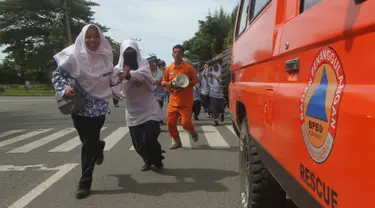 Sejumlah murid berlari saat berpartisipasi dalam latihan tsunami di Meulaboh, Aceh, (5/9). Latihan ini menyimulasikan gempa berkekuatan 9,3 di lepas pantai barat pulau Sumatra di Indonesia. (AFP Photo/Januar)